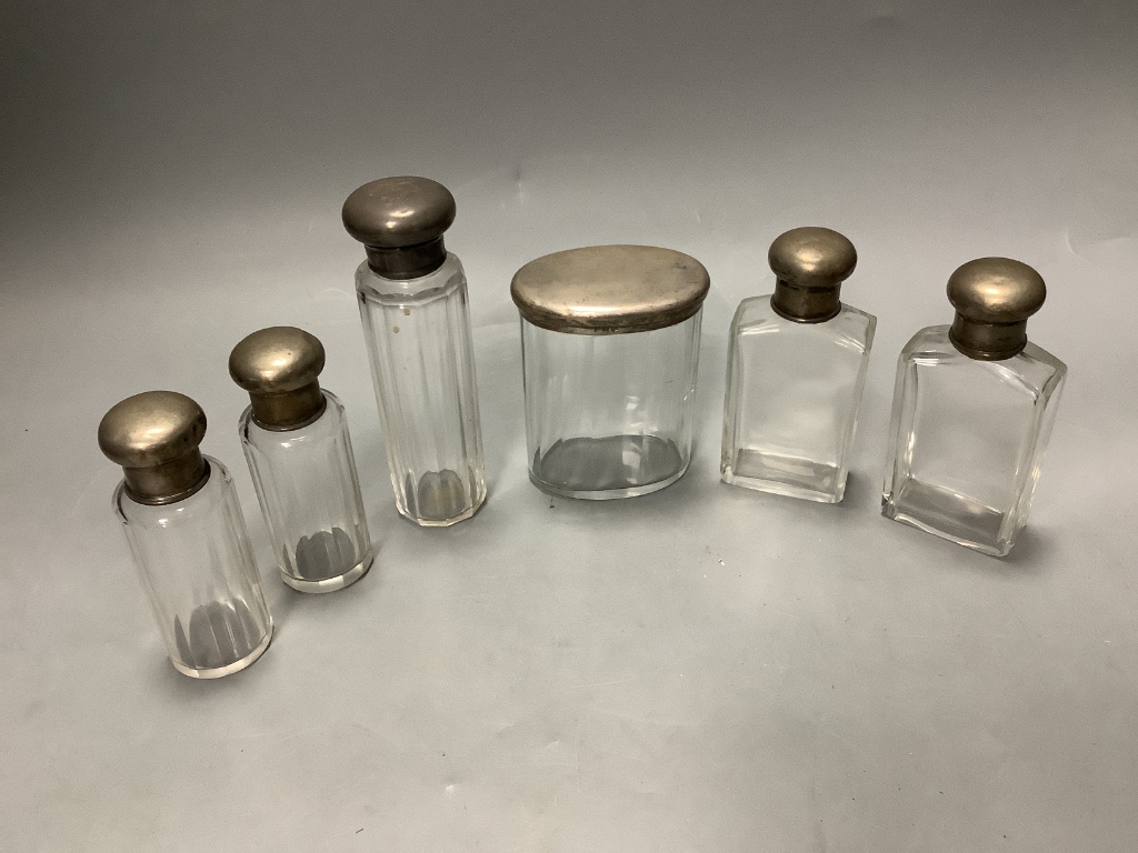 Six assorted silver mounted glass toilet jars, tallest 13.9cm.